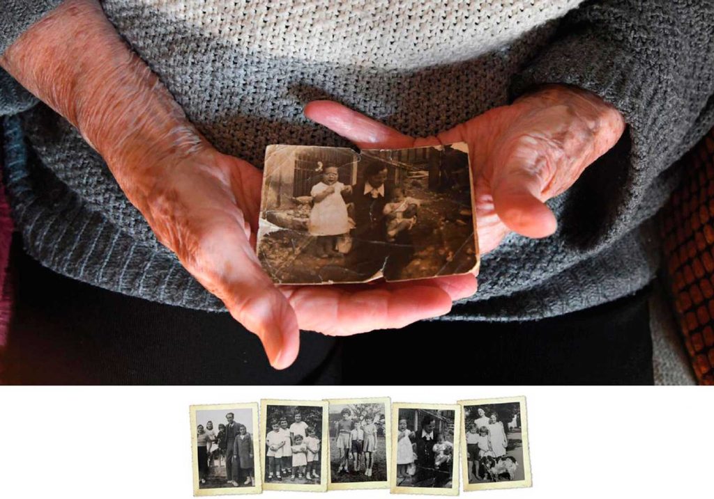 Las manos de una persona anciana muestran una fotografía antigua. Debajo, 5 fotografías familiares antiguas