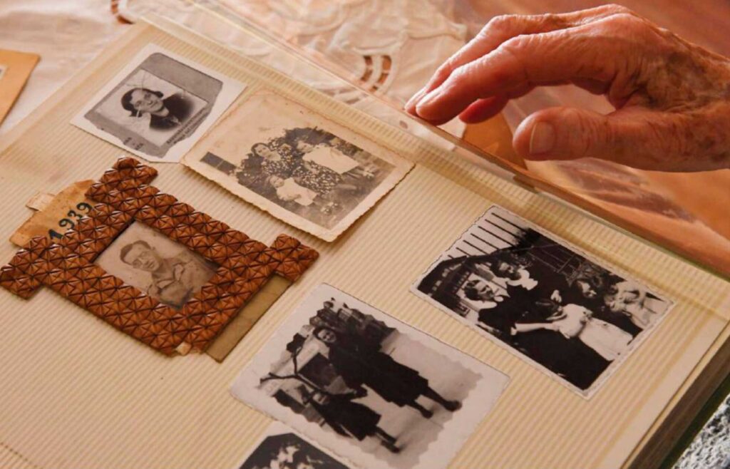 La. mano de una persona anciana pasa páginas en un álbum de fotos antiguas