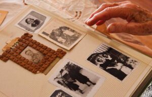 La. mano de una persona anciana pasa páginas en un álbum de fotos antiguas